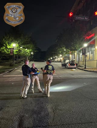 Police stand near the CVS where officials say a gunman opened fire on Friday, killing a police officer and firing several rounds at the CDC campus. No civilians were injured, police said